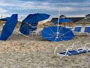 Wind tossed beach furniture and umbrellas.