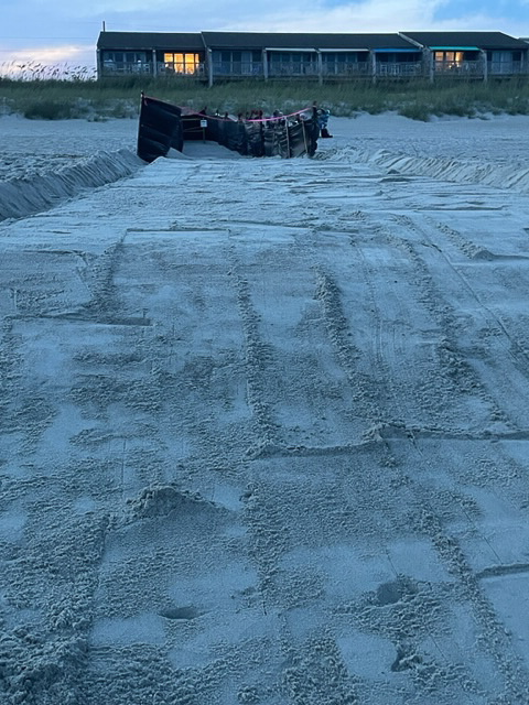 Sea turtle nest with shade cloth to protect from light pollution with a smoothed trench and sand gutters to the ocean.
