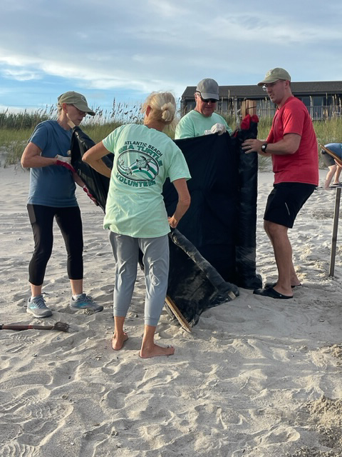 Volunteers installing black shade cloth around a sea turtle nest to protect hatchlings from light pollution.