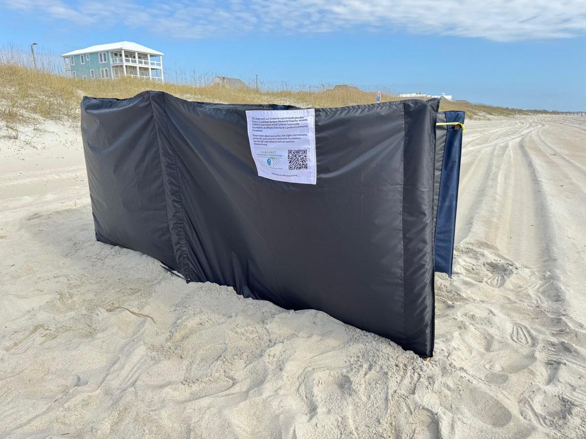 Shade cloth to block artificial light surrounding a sea turtle nest on the beach.